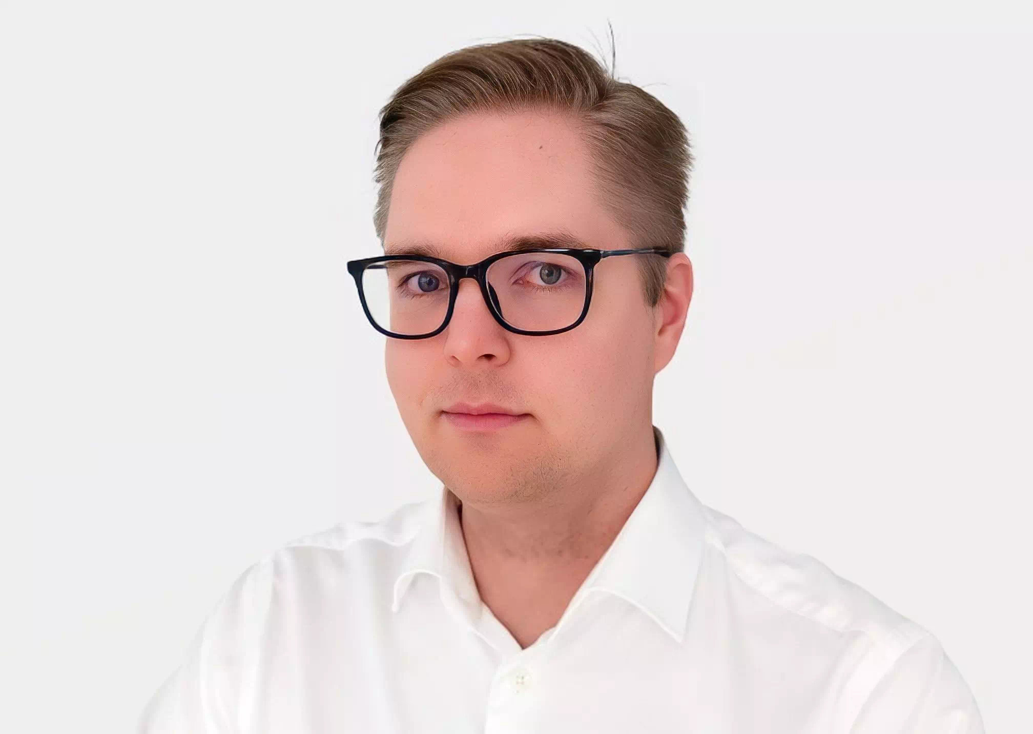 Juho Tikka Finnish white man wearing white shirt with black framed glasses